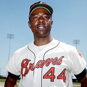 Hank Aaron of the Atlanta Braves holds up the playing shirt of his former  teammate, Eddie Mathews after Braves officials announced that the number  will be retired now that Mathews has been
